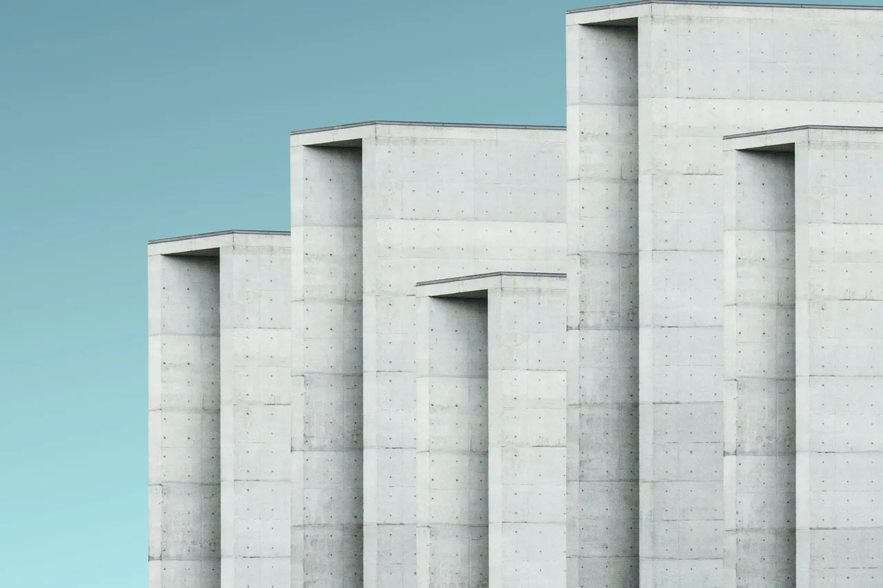 Stepped concrete building forms with recessed openings and visible casting marks