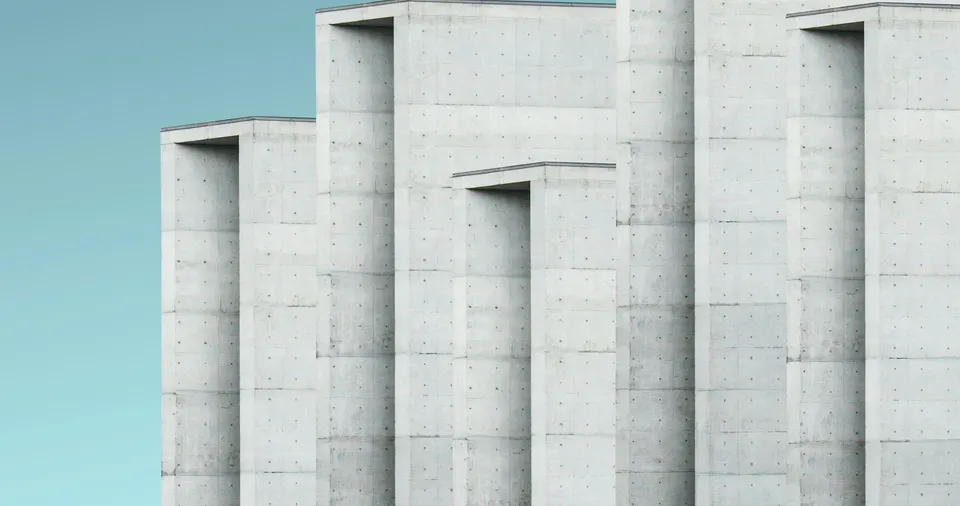 Stepped concrete building forms with recessed openings and visible casting marks